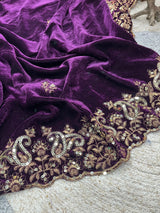 Purple fabric with intricate gold embroidery on a textured surface