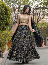 Woman in a black and gold traditional outfit walking outdoors.